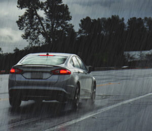 silver sedan driving in rain