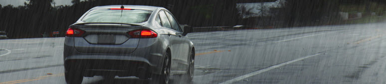 silver sedan driving in rain